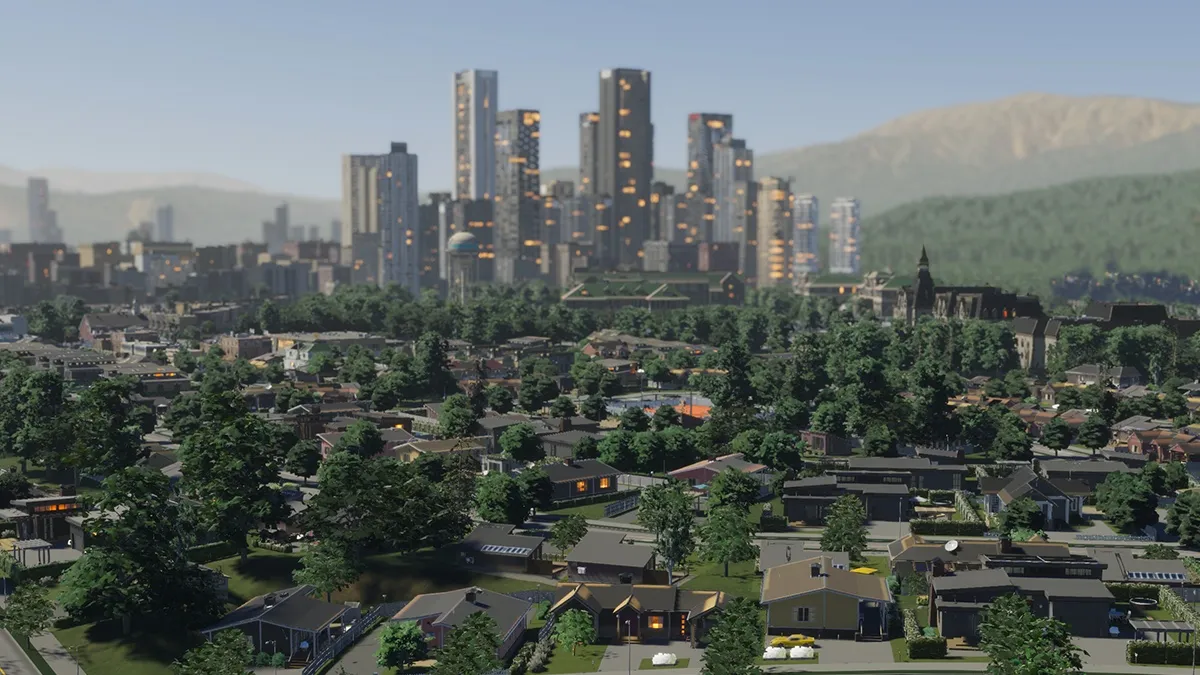 Suburban sprawl intermixed with trees stretches in front of a larger city with skyscrapers.
