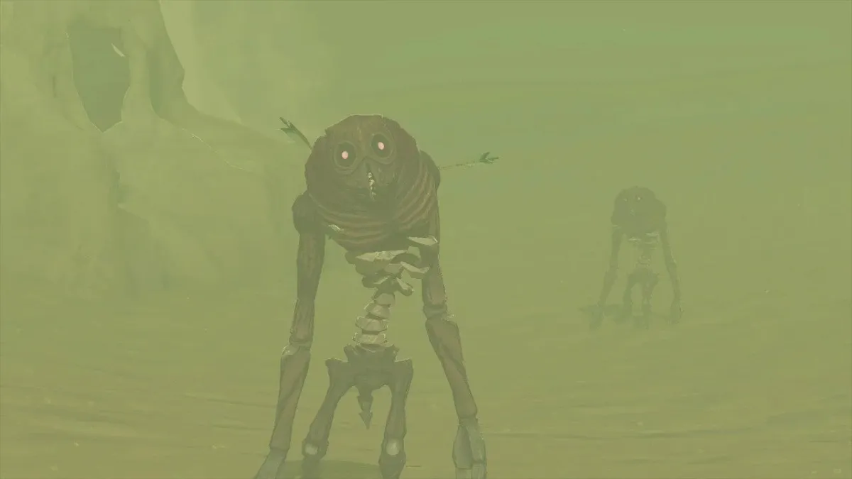 A pair of Gibdos wander ominously out of a sand storm. They are skeletal and have glowing eyes peering out from dark masks. You can see their spine and ribs clearly. The Gibdo in the front seems to have some arrows sticking out of it, proof of how resilient these creatures are. 