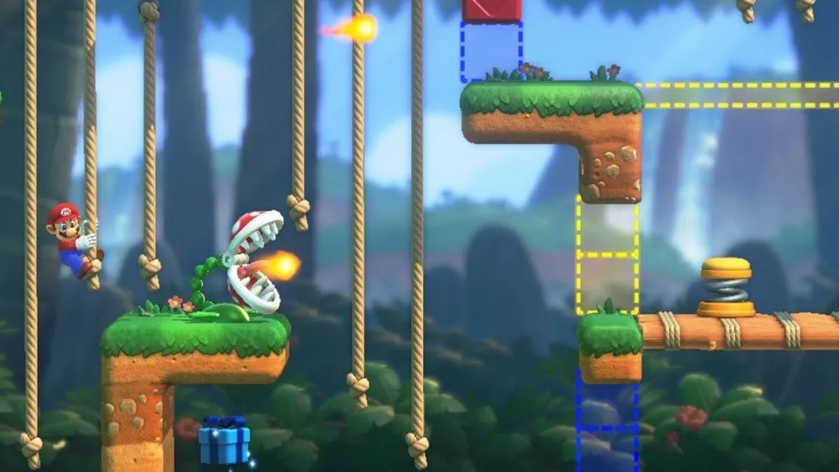Mario climbs a rope and evades a flame-spewing Piranha Plant. The obstacle course is made of dirt and grass, the background features a tropical jungle with palm trees and a large double waterfall. 