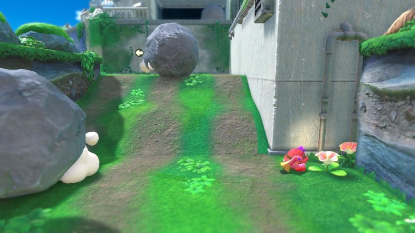 Kirby stands near the entrance to a path by a white flower.